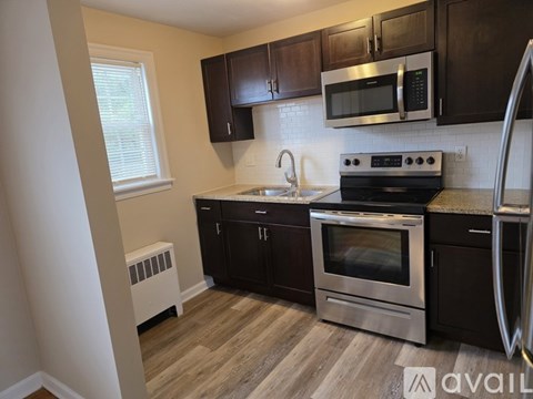 A kitchen with black cabinets and stainless steel appliances.
