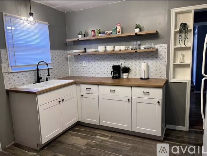 A kitchen with white cabinets and a wooden countertop.