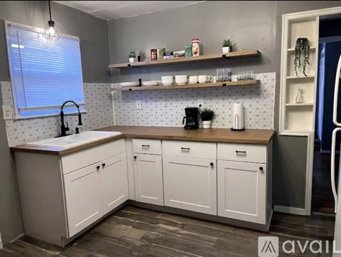 A kitchen with white cabinets and a wooden countertop.
