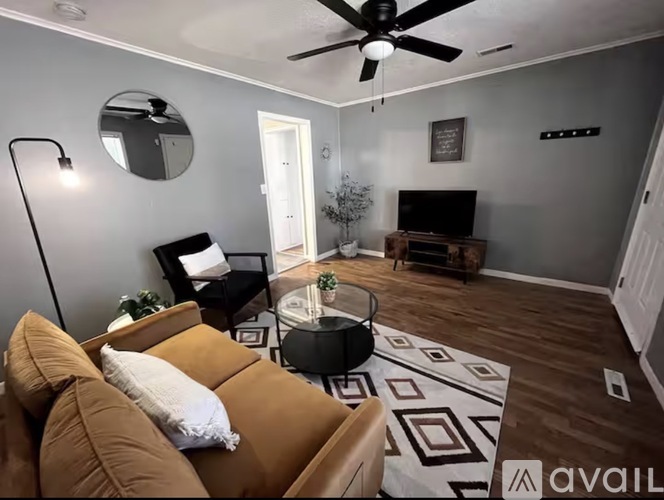 A living room with a brown couch and a black floor lamp.