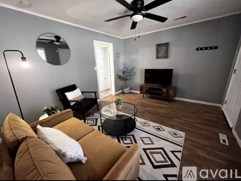 A living room with a brown couch and a black floor lamp.
