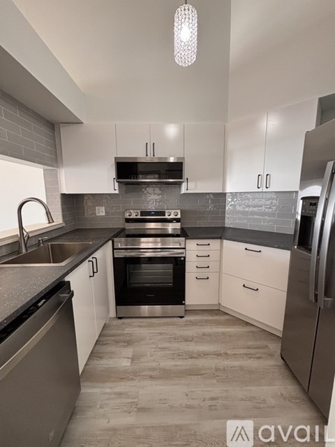 A kitchen with white cabinets and stainless steel appliances.