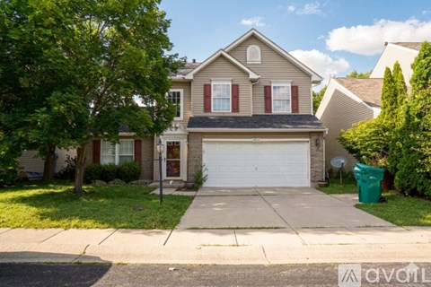 A two-story house with a garage and a driveway.