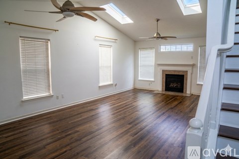 A spacious room with wood flooring and a fireplace.