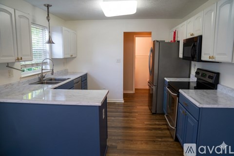 A kitchen with a marble countertop and dark blue cabinets.