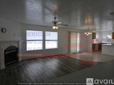 A spacious room with a fireplace and a ceiling fan.