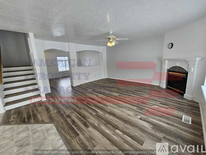 A living room with wooden flooring and a staircase.