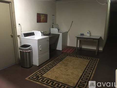 A room with a printer, a trash can, and a small table.