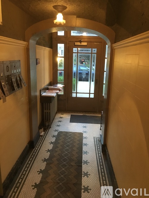 A hallway with a tiled floor and a door at the end.