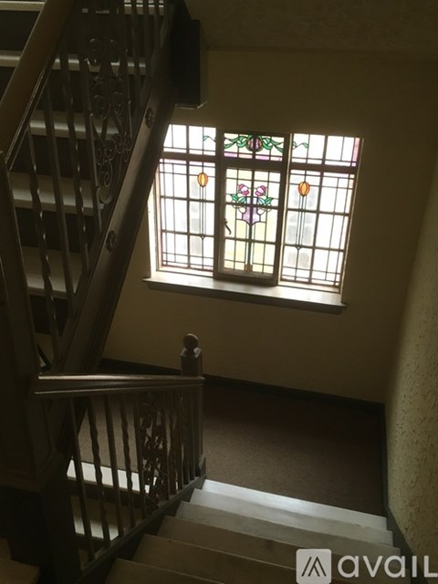 Stained glass window in a room with a staircase.