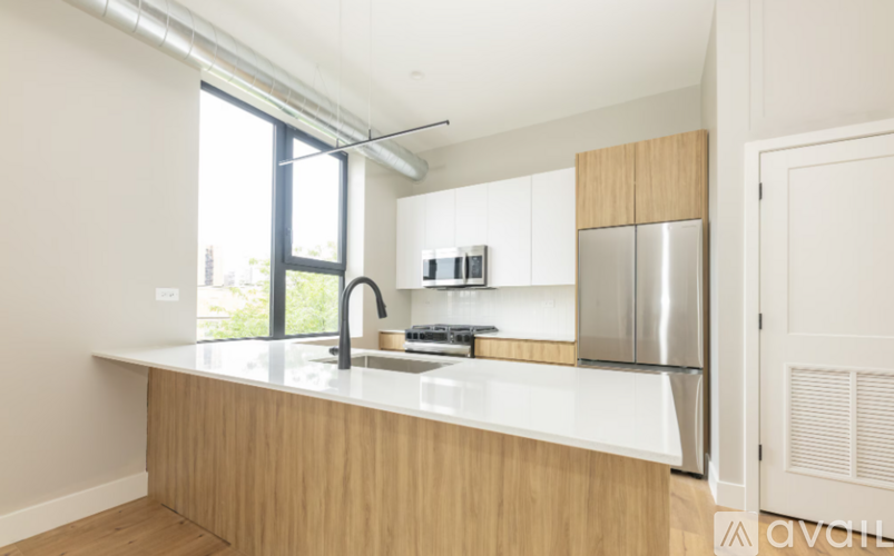 A kitchen with wooden cabinets and a stainless steel refrigerator.