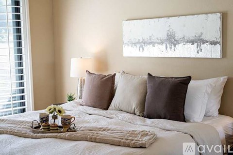 A bedroom with a large bed and a painting on the wall.