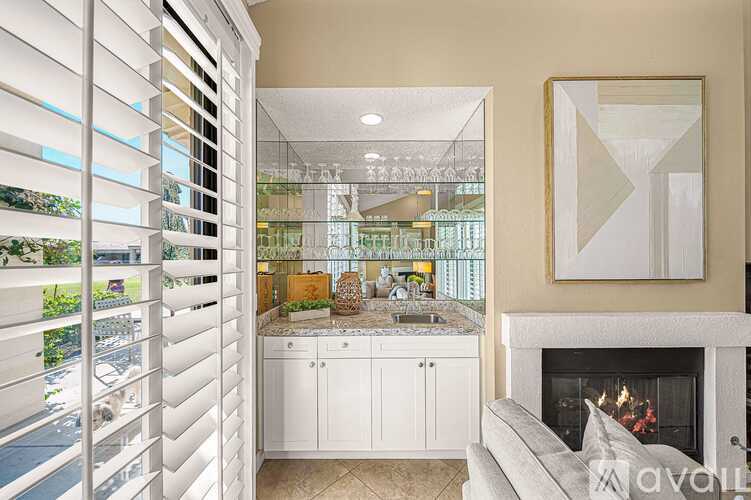 A modern kitchen with white cabinets and a fireplace.
