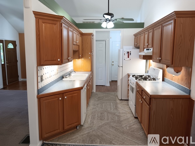 A kitchen with wooden cabinets and a white stove top oven.