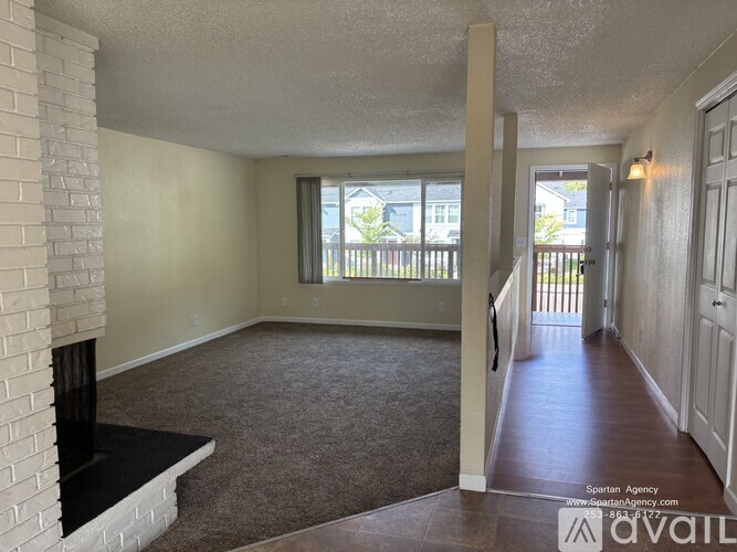 A living room with a fireplace and carpeted floor.