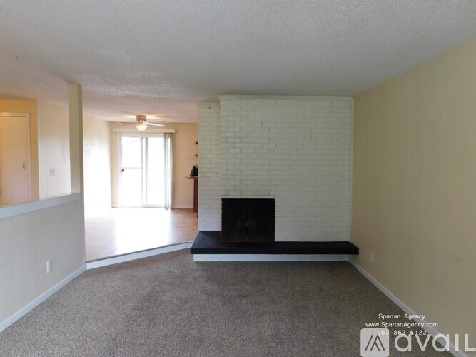 A living room with a fireplace and a carpeted floor.
