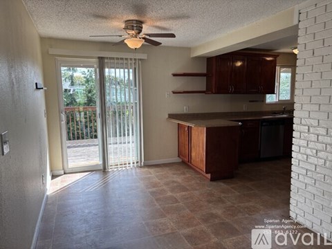 A kitchen with brown cabinets and a ceiling fan.