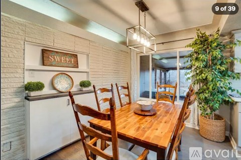 A dining room with a wooden table and chairs.