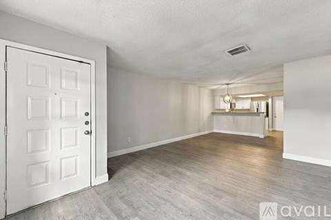 A room with a white door and a wooden floor.