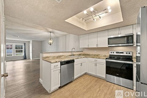 A kitchen with white cabinets and stainless steel appliances.