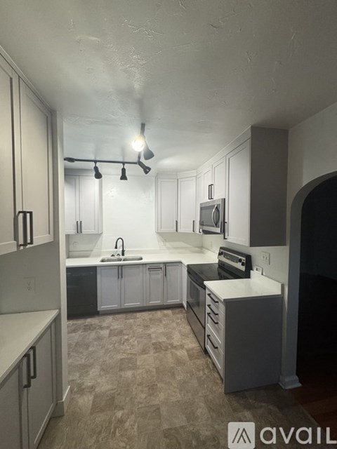 A kitchen with white cabinets and a sink.