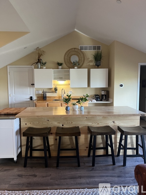 A kitchen with a bar stool in front of the counter.