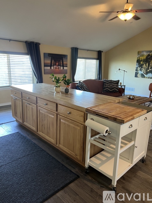 A kitchen island with a wooden top and drawers is in the middle of the room.