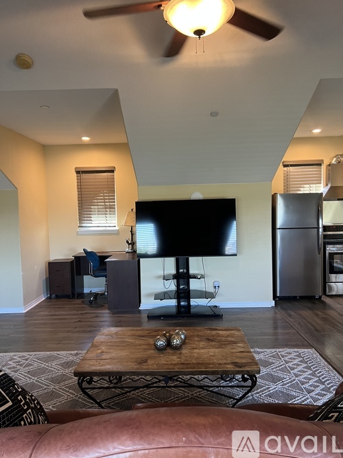 A living room with a television, a coffee table, and a couch.