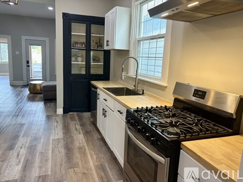 A kitchen with a black and white color scheme and a wooden floor.