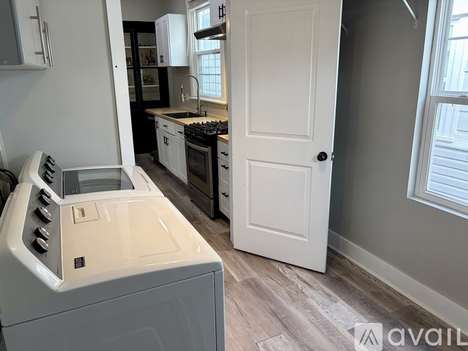 A white oven with a stove top sits in a kitchen with a white door.