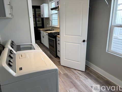 A white oven with a stove top sits in a kitchen with a white door.