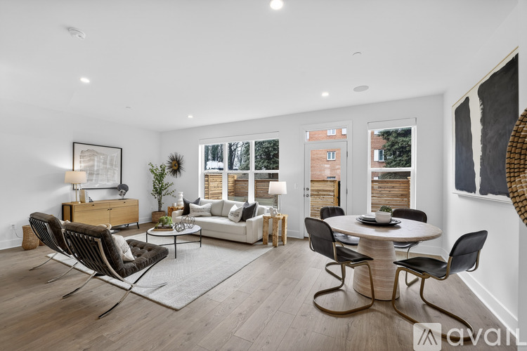 A modern living room with a white table and black chairs.