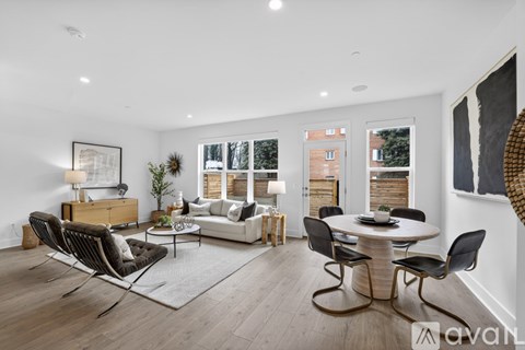 A modern living room with a white table and black chairs.