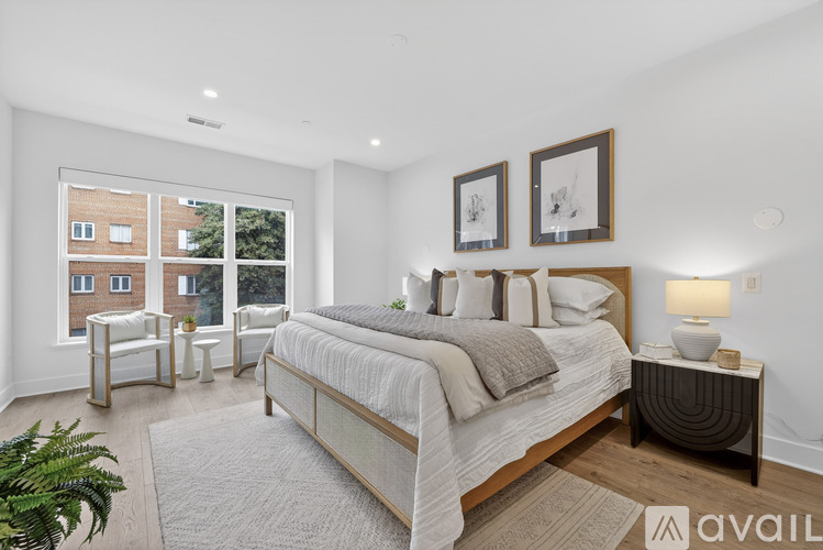 A bedroom with a large bed and a balcony with a view of a building.