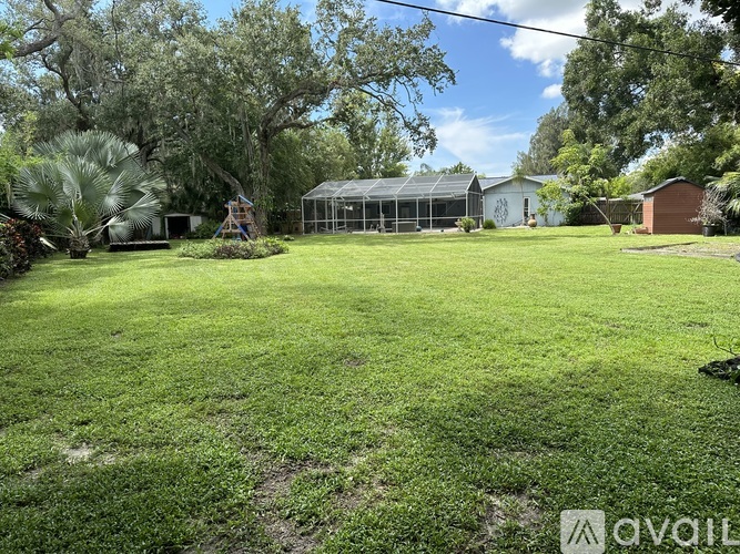 A backyard with a green lawn and a playground.