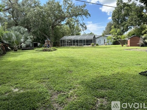 A backyard with a green lawn and a playground.