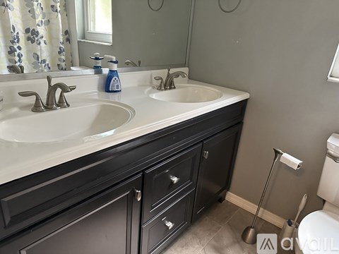 A bathroom with two sinks and a toilet.