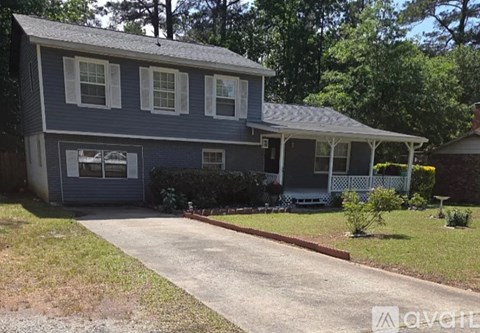 A two-story house with a garage and a covered porch.