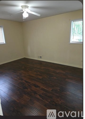A room with wooden flooring and a ceiling fan.