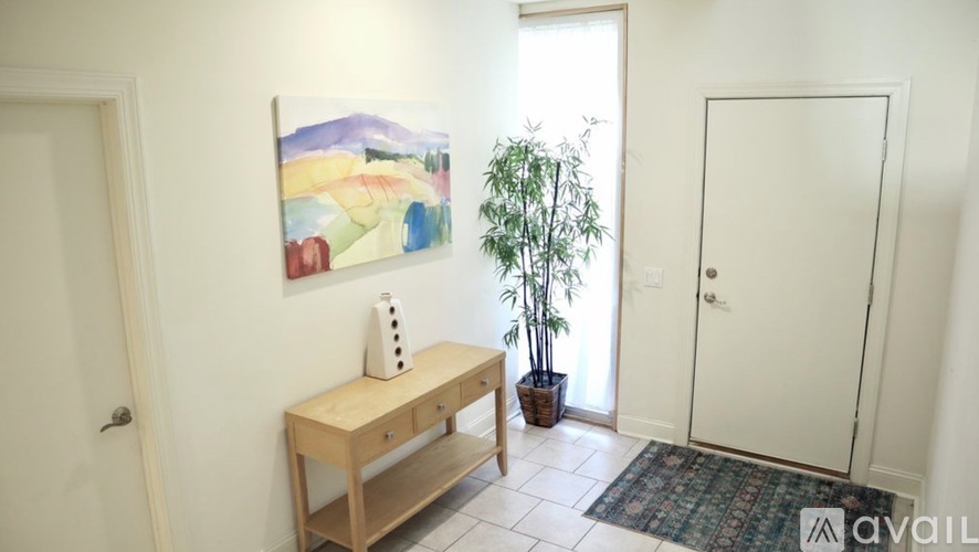 A room with a painting, a wooden bench, and a potted plant.