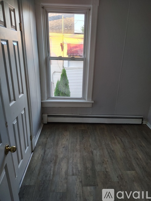 A room with a wooden floor and a white door.