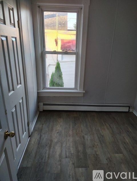 A room with a wooden floor and a white door.