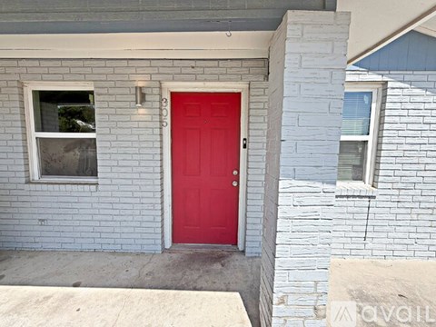 A red door is the centerpiece of this house.