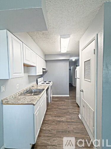 A kitchen with white cabinets and a granite countertop.