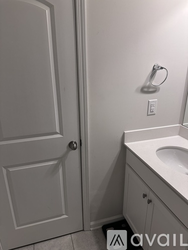 A white bathroom with a sink and a door.