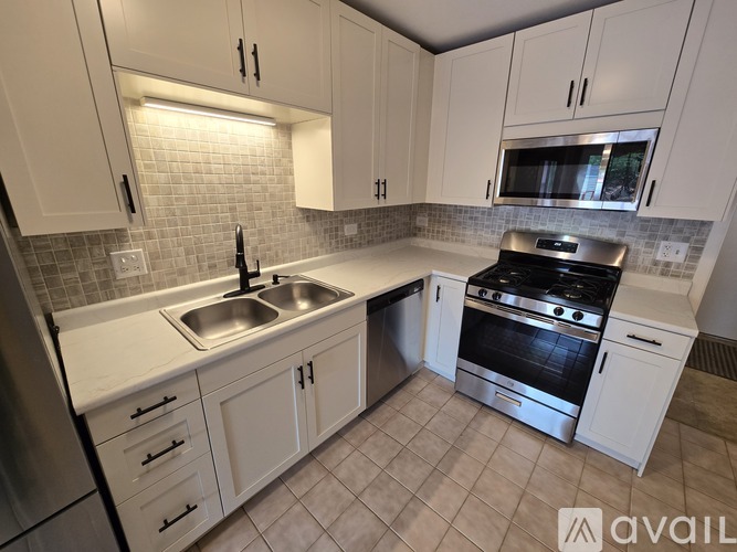 A kitchen with white cabinets and a stainless steel oven.