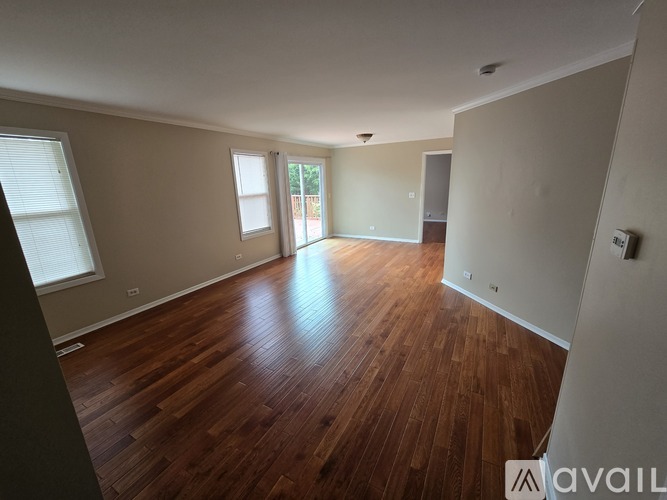 A room with wooden flooring and a door leading outside.