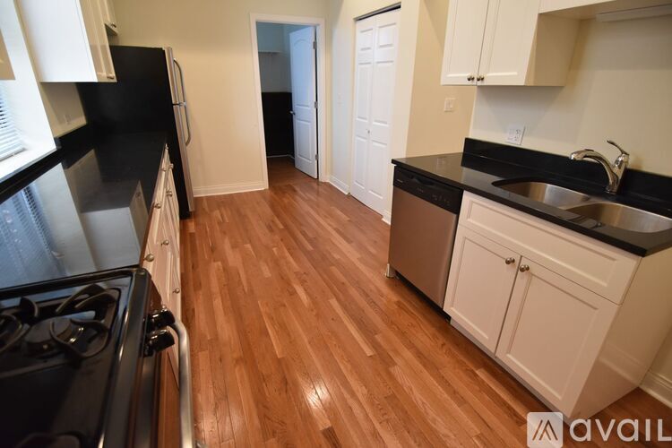 A kitchen with black countertops and white cabinets.