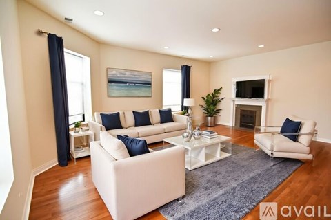 A living room with white furniture and a fireplace.