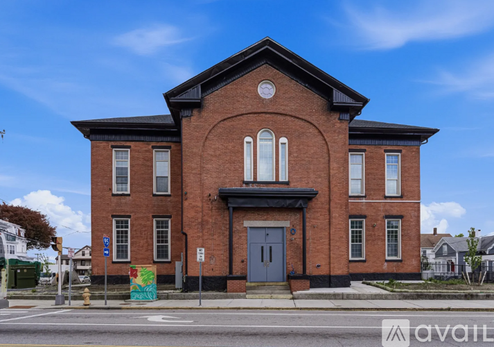 A red brick building with a blue door and windows.